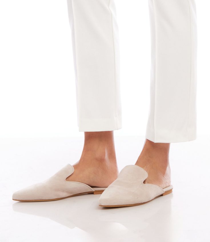 From daytime strolls to evening soirees, these handcrafted mules seamlessly transition from one event to the next. The suede material not only exudes a luxurious aesthetic but also conforms to your foot, providing a personalized and comfortable fit. 100% Leather Imported Flat Sole Runs small; we recommend sizing up Avoid water - rub with dry cloth | Karen Kane Suede Leather Mules in Cream, Size 37, Plain Fall Evening Slip-on Mules, Elegant Slip-on Slippers With Round Toe, Evening Slip-on Flats For Spring, Formal Beige Slip-ons For Spring, Elegant Summer Slip-ons With Round Toe, Chic Beige Almond Toe Slip-ons, Elegant Slip-on Slippers With Leather Sole, Chic Closed Toe Slip-ons With Branded Insole, Formal Suede Slip-ons With Almond Toe