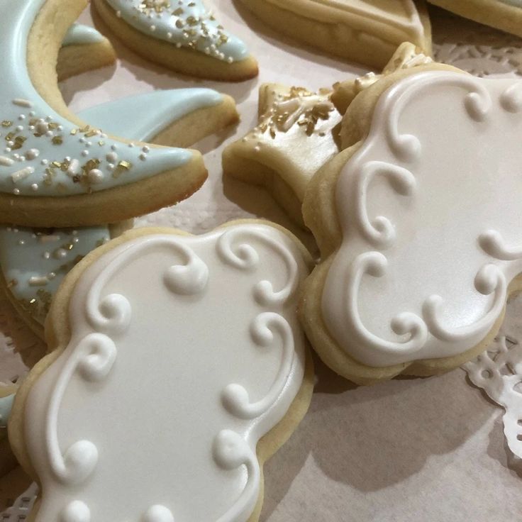 several decorated cookies sitting on top of a white doily next to eachother