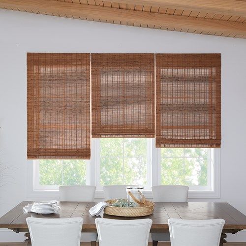 a dining room table with four chairs and bamboo blinds