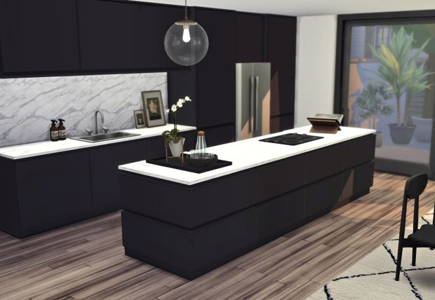 a modern kitchen with black cabinets and white counter tops