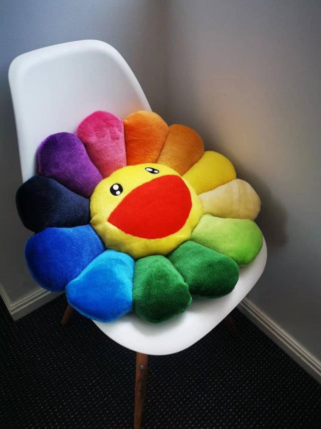 a colorful stuffed animal sitting on top of a white chair