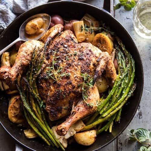 chicken, potatoes and asparagus in a cast iron skillet