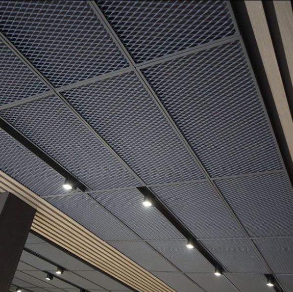 the ceiling in an office building is made of metal and has dim lights on it