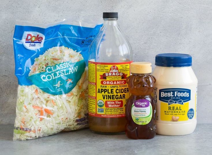 ingredients to make coleslaw are displayed on a counter top with a bag of coleslaw in the background