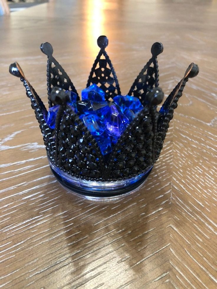 a glass crown sitting on top of a wooden table