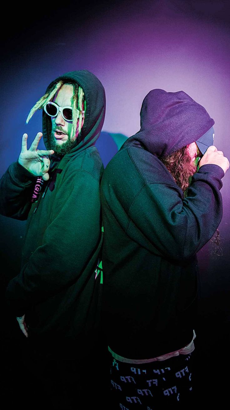 two young men with dreadlocks standing next to each other in front of a purple background