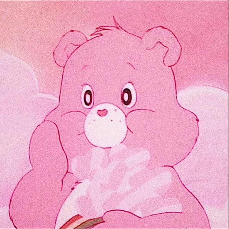 a pink teddy bear sitting on top of a bed