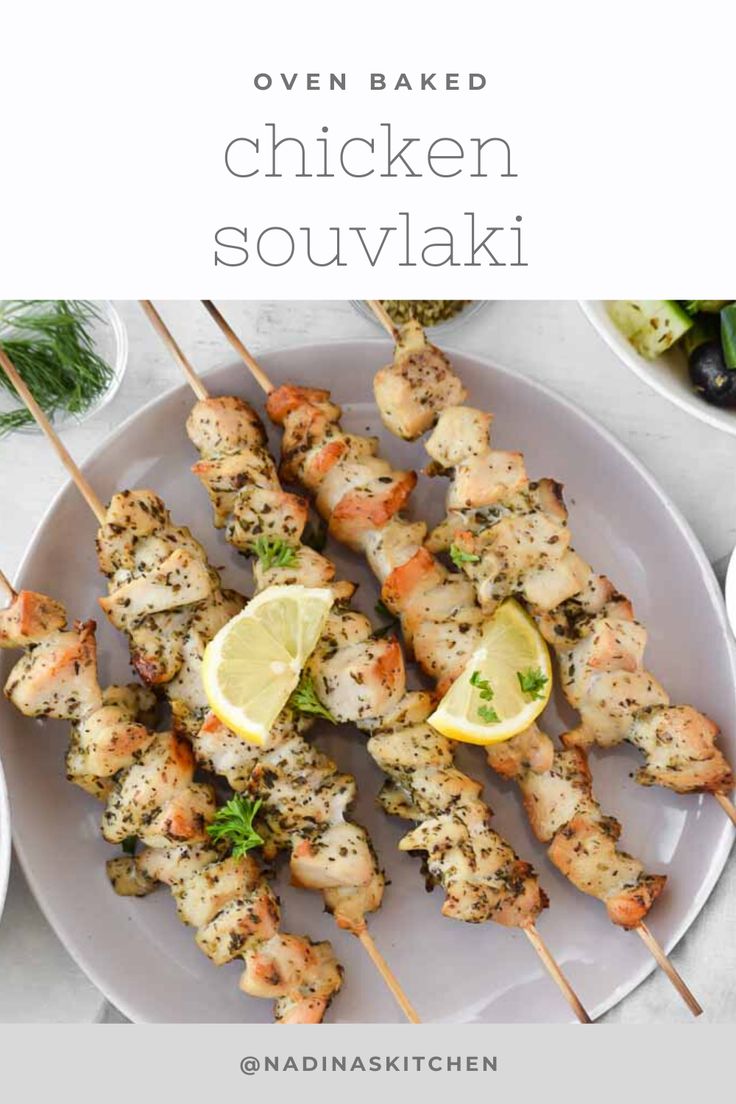 chicken skewers on a plate with lemon wedges and garnishes