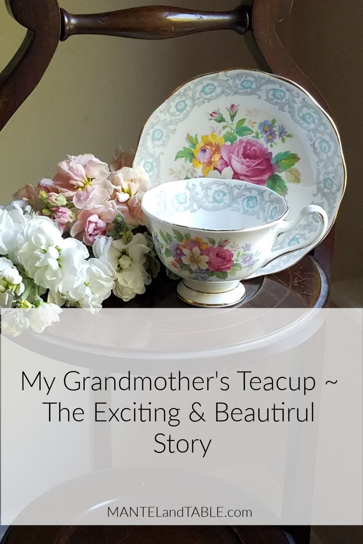 a teacup and saucer sitting on top of a table with flowers in it