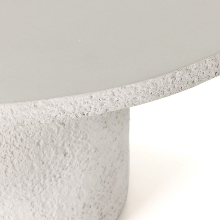 a close up of a white table on a white surface with no one around it