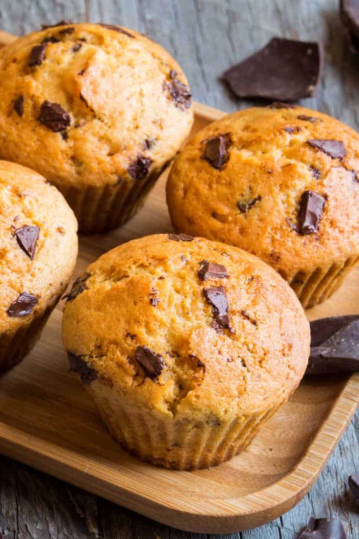 four chocolate chip muffins on a cutting board