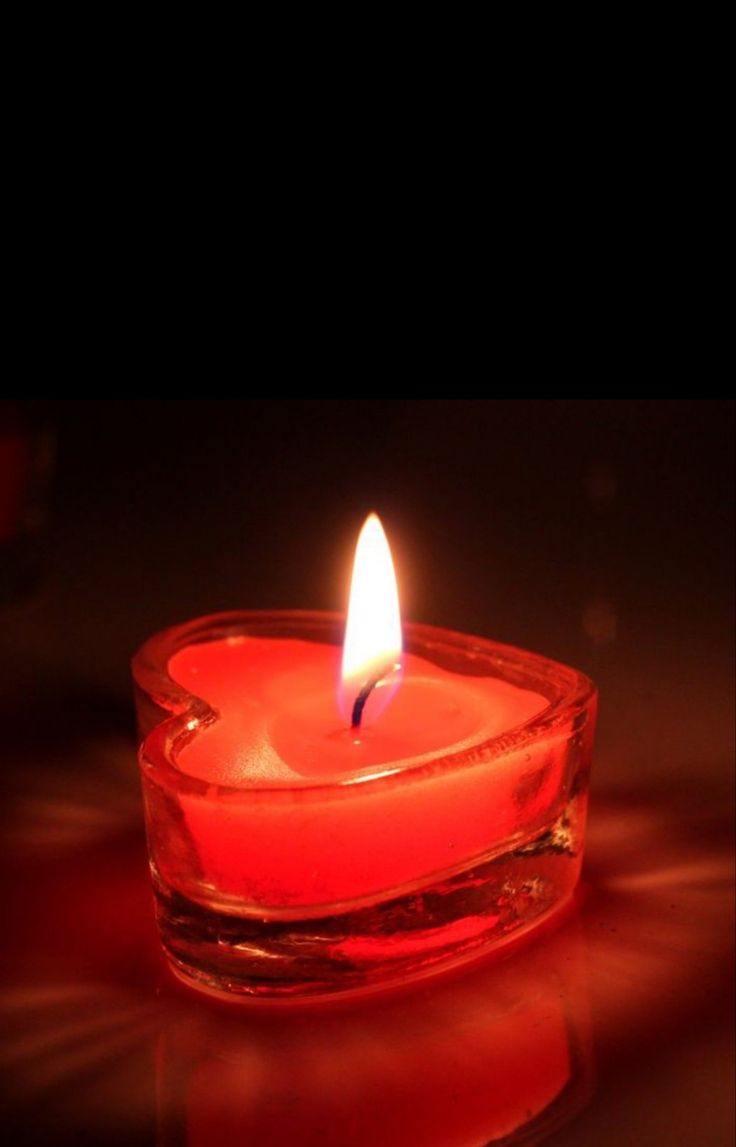 a lit candle sitting in a glass bowl