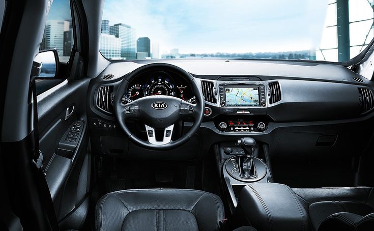 the interior of a car with dashboard, steering wheel and center console in front of cityscape