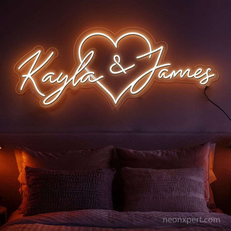 a neon sign that says kayla and james on it's wall above a bed