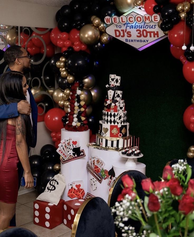 a man and woman standing in front of a table with casino themed cakes on it