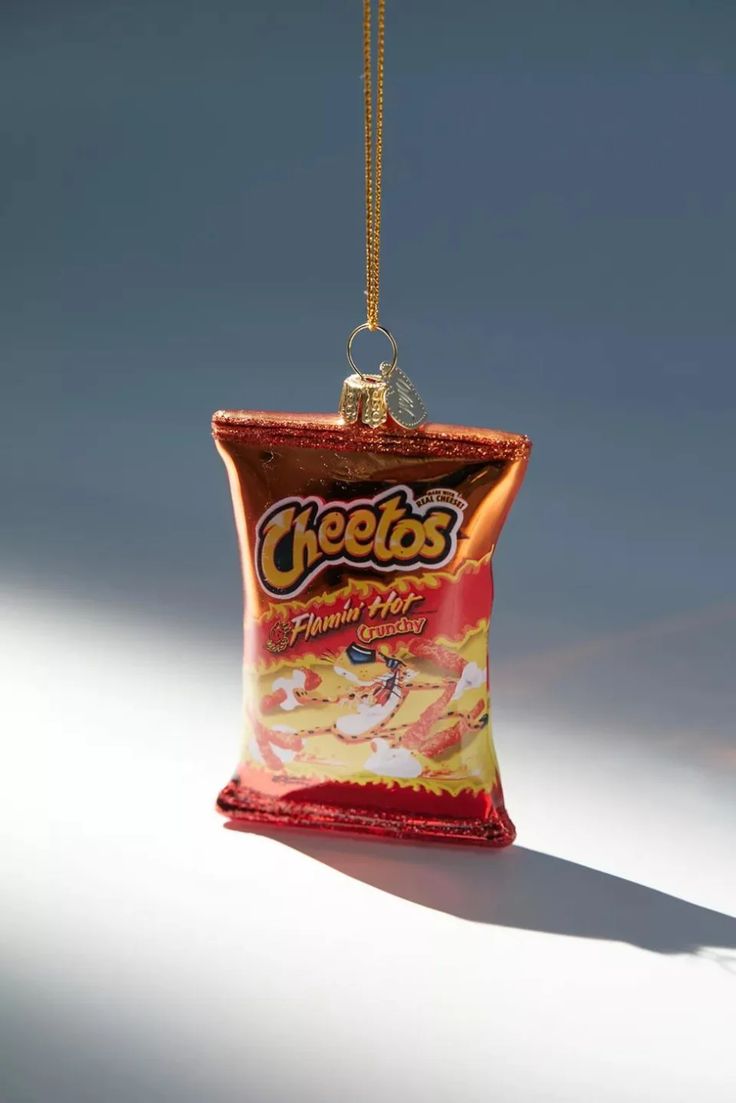 a bag of cheetos sitting on top of a white table next to a gold chain