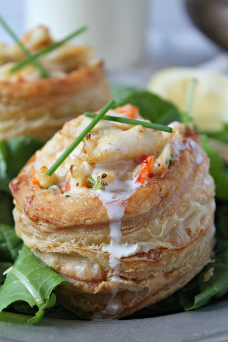 a close up of a plate of food with spinach and crab cakes on it