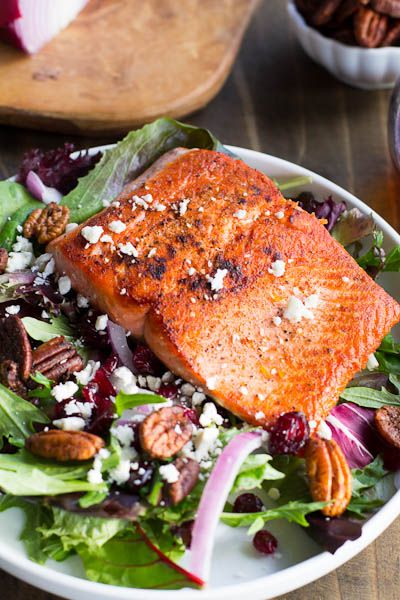 a white bowl filled with salad and salmon