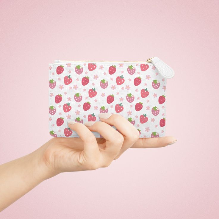 This compact Strawberries and Daisies Mini Clutch Bag is perfect for holding all your essentials on the go. Its cute and pretty design adds a touch of style to any outfit. With this handy bag, you can keep your belongings organized and easily accessible. Designed to be chic and highly portable, this mini clutch bag is made for anyone on the go. It can hold everyday essentials such as a phone, a wallet, and keys. It features a zip fastener and it is made of vegan, cruelty-free leather. .: Material: 100% polyurethane faux leather .: Double-sided print with Saffiano pattern finish.: One compartment for cash, cards, other small items.: Black lining.: Metal zipper closure 6.3” x 4” Width, in 6.30 Height, in 4.02 Depth, in 0.31 Trendy White Pencil Case For Daily Use, Cute Rectangular Cosmetic Bag For Everyday Use, Cute Bags With Card Slots For Gifts, Rectangular Strawberry Print Bag For Gifts, Rectangular Bags With Strawberry Print For Gifts, Rectangular Bags With Strawberry Print As Gift, Rectangular Bag With Strawberry Print As Gift, Rectangular Strawberry Print Bag As A Gift, Cute White Wallets For Gifts