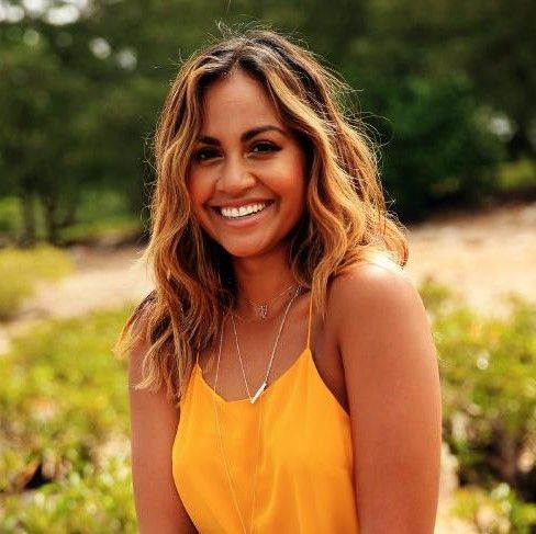 a woman in a yellow dress is smiling for the camera