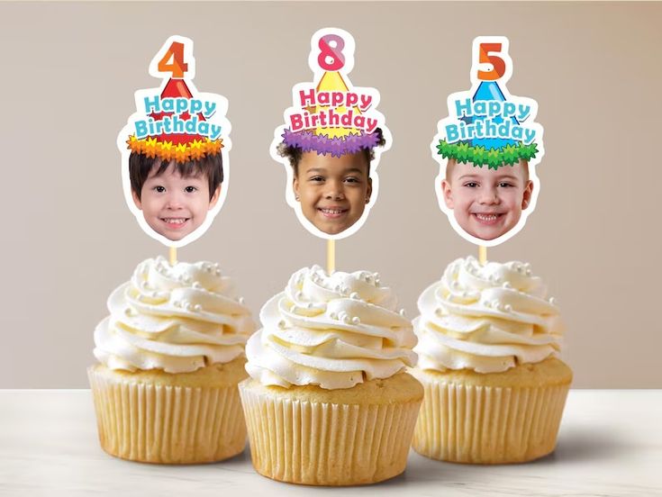 three cupcakes with candles on top of them and the faces of two children