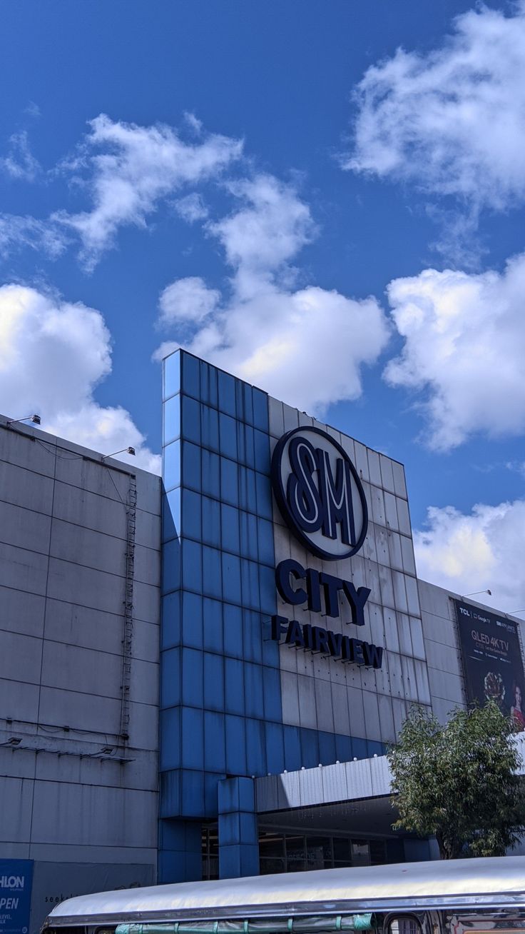 a bus parked in front of a building under a cloudy blue sky