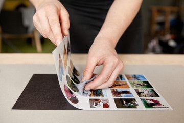 a person is placing pictures on a table with their hands in the photo album,