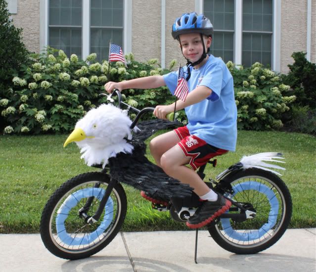 a young boy riding on the back of a bike with an eagle decoration on it