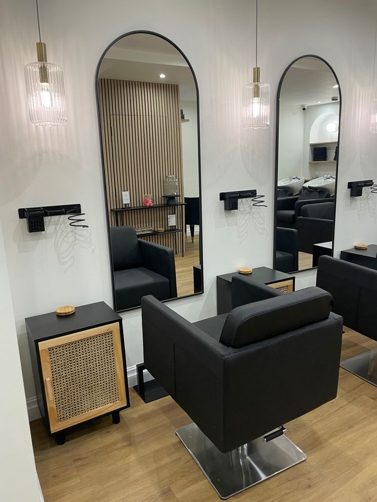 a hair salon with black chairs and mirrors