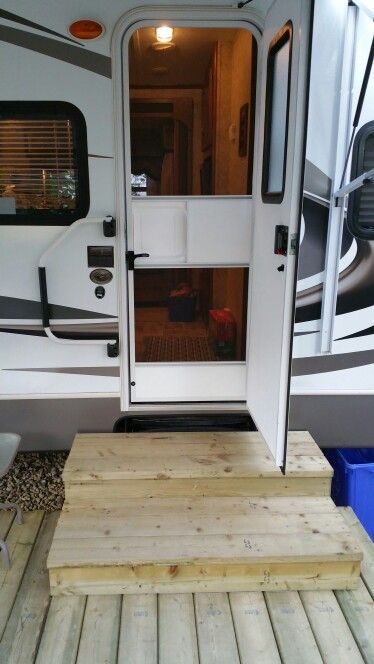 an rv with stairs leading to the front door