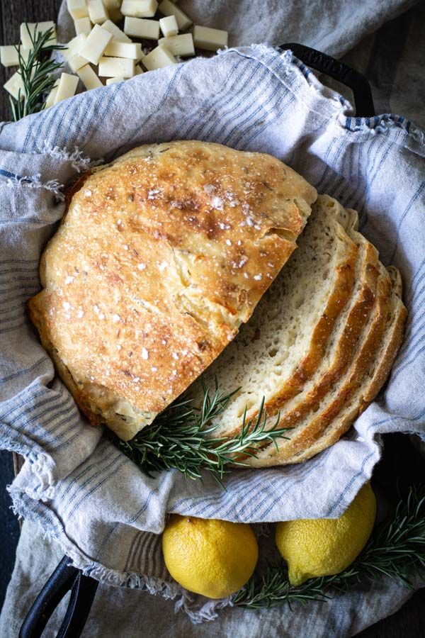 a loaf of bread sitting on top of a table next to lemons and cheese