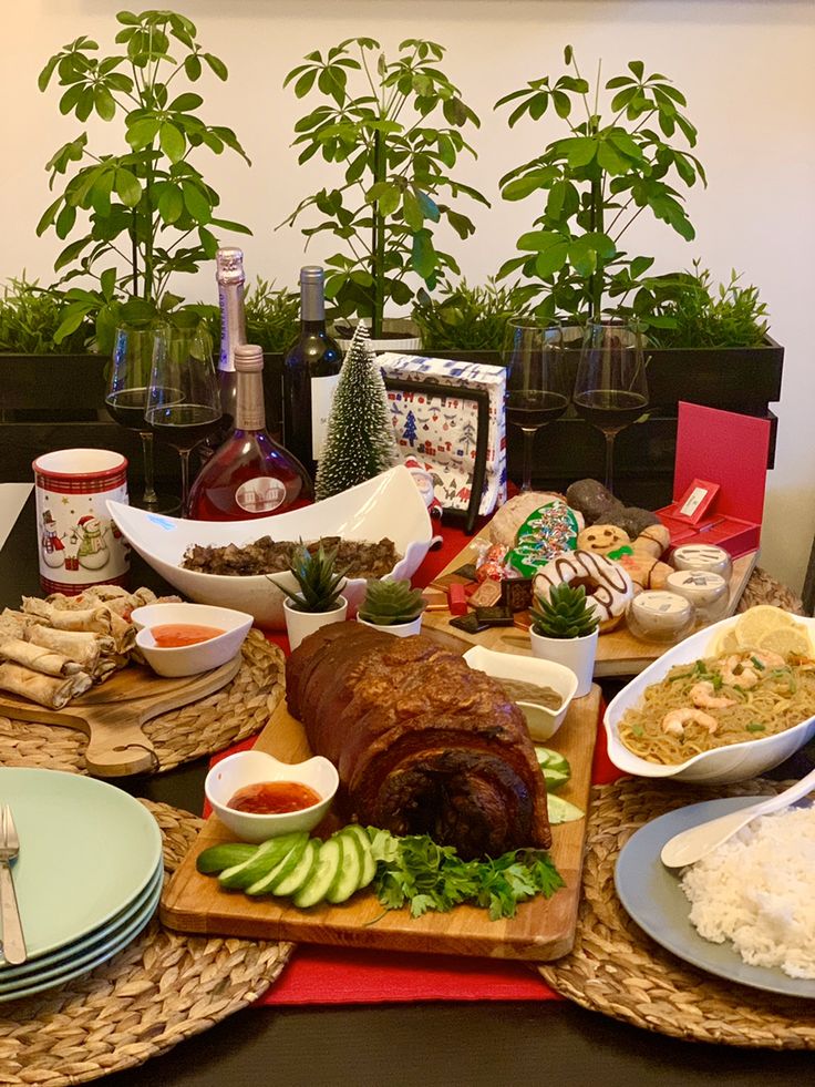 a table filled with plates and bowls of food next to potted plants in pots