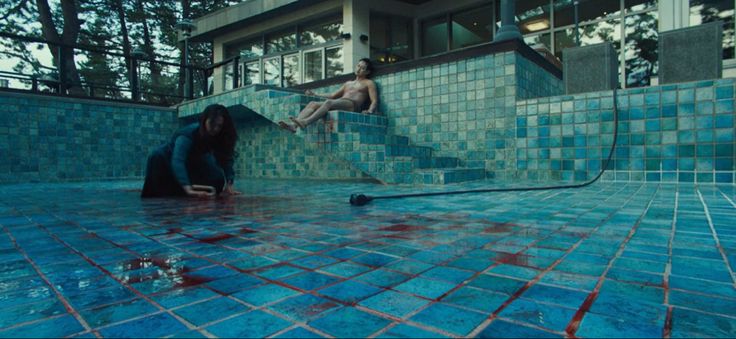 two people are swimming in a pool with blue tiles on the floor and one person is upside down