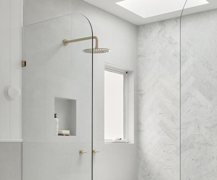 a bathroom with marble walls and flooring, including a walk - in shower next to a window