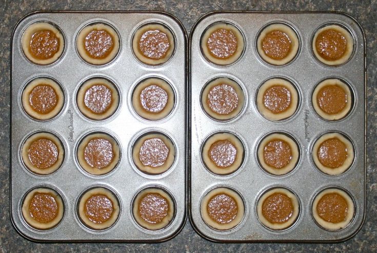 two pans filled with cupcakes sitting on top of a counter