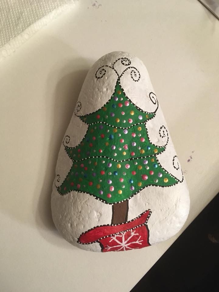 a painted rock with a christmas tree on it