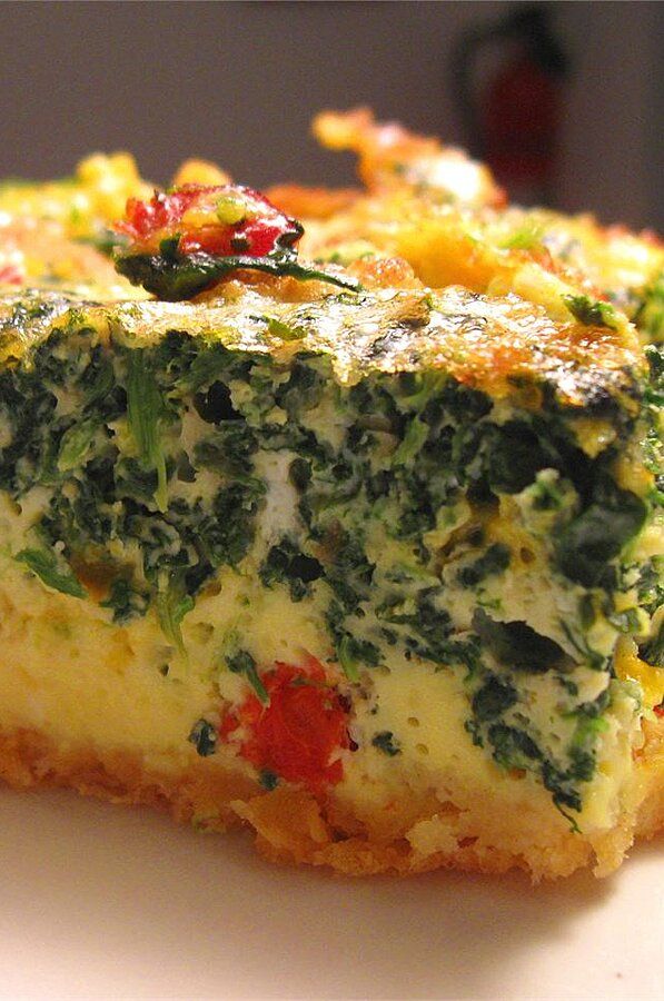 a piece of quiche with spinach and cheese