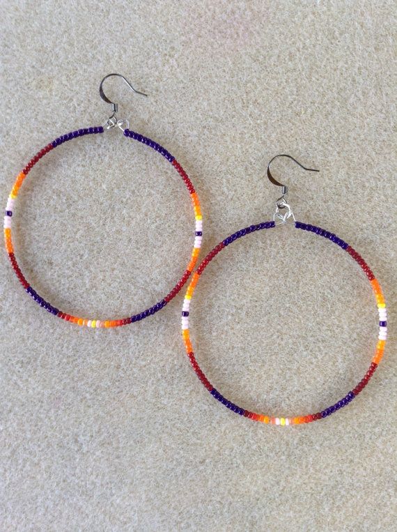 two pairs of beaded hoop earrings sitting on top of a white carpeted floor