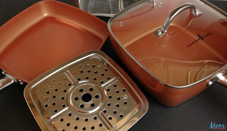 two copper colored pots and pans sitting on a black counter top next to each other