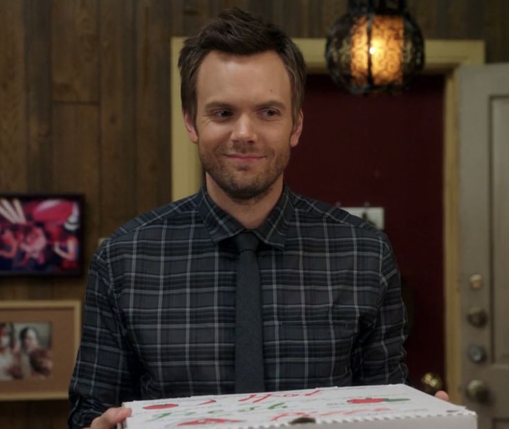 a man in a tie holding a cake