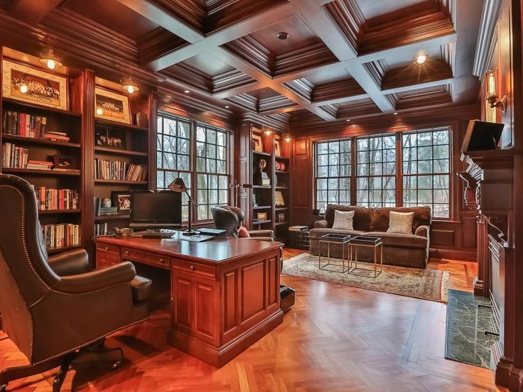 an elegant home office with wood paneling and built - in bookshelves