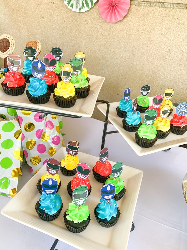 cupcakes are arranged on three trays in the shape of cars