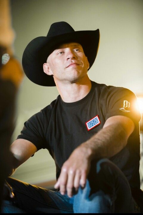 a man in a black shirt and cowboy hat