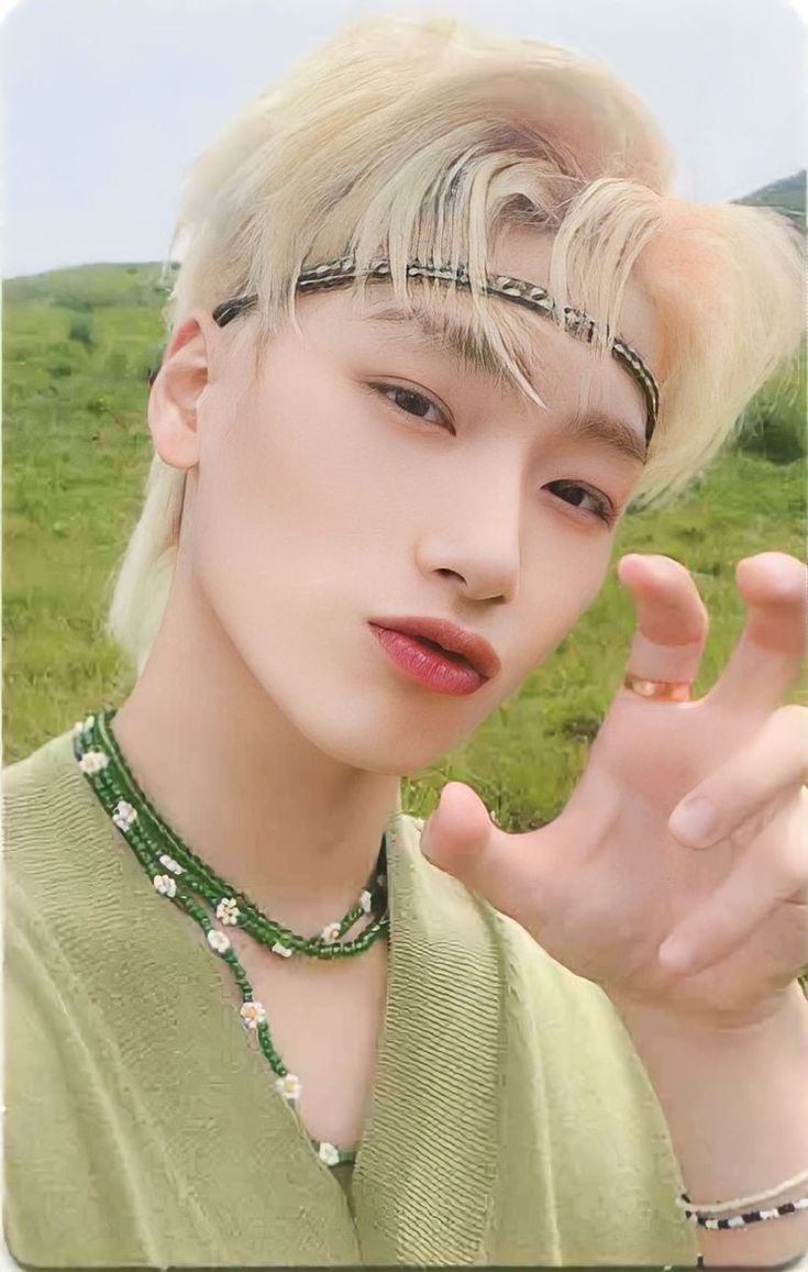 a young man with blonde hair and piercings on his head is posing for the camera