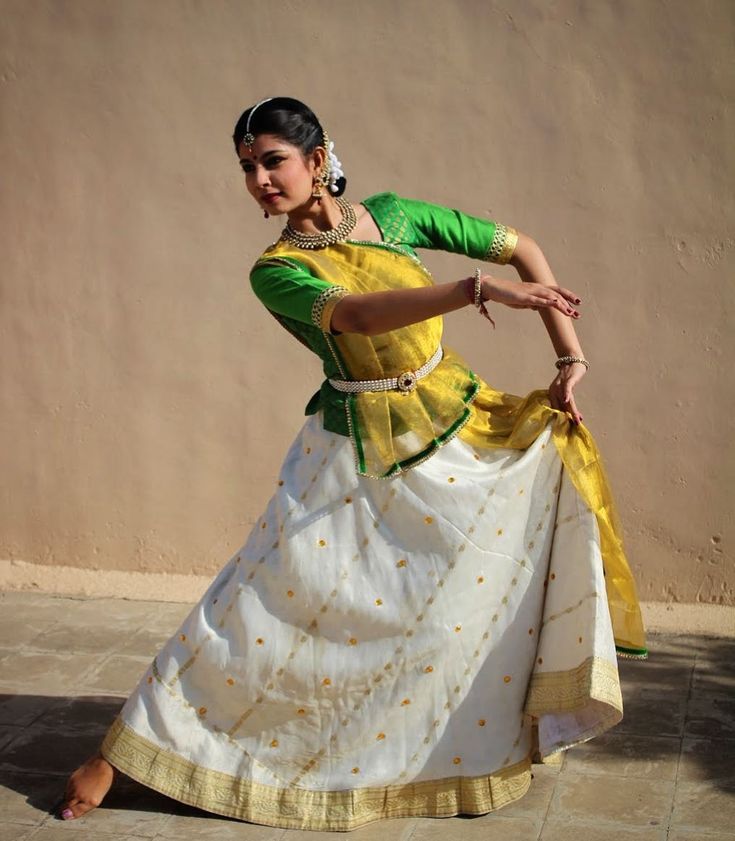 a woman in a yellow and white dress is dancing