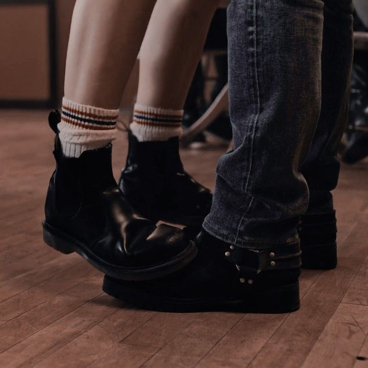 two people standing next to each other on top of a hard wood floored floor