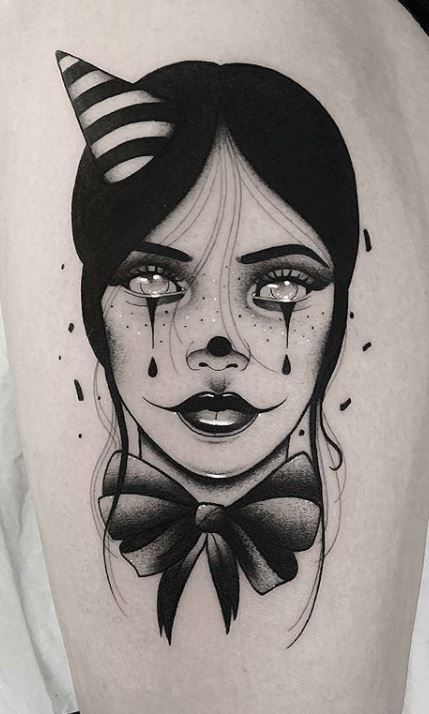 a woman's thigh with a creepy face and bow tie tattoo design on it