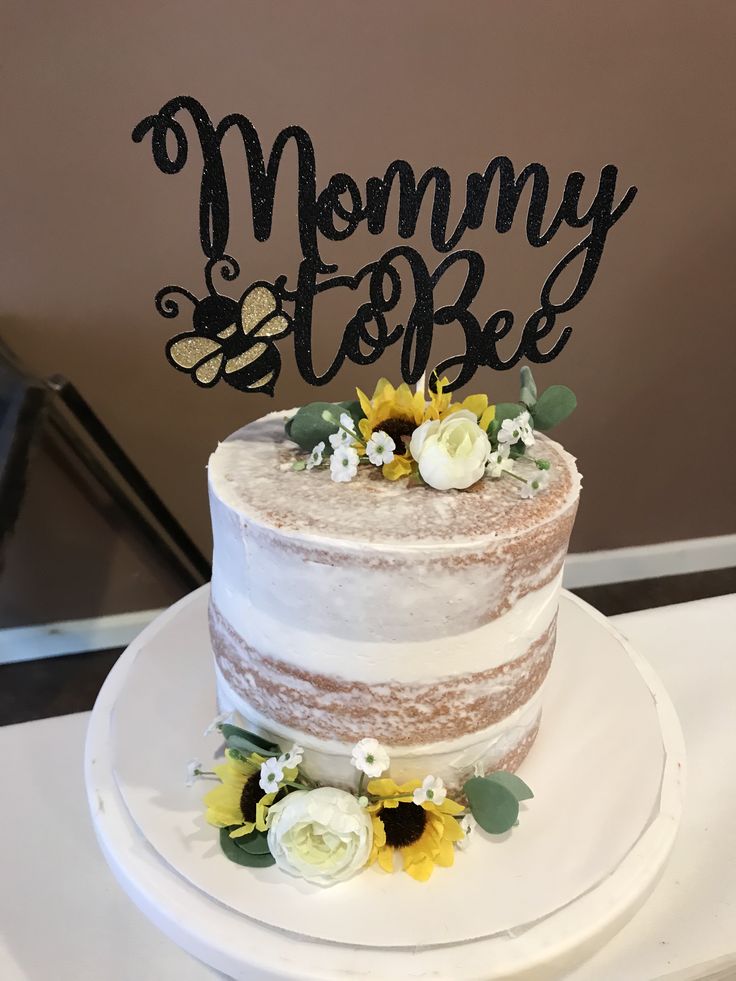 there is a cake that has been decorated with sunflowers and the words mommy to be on it