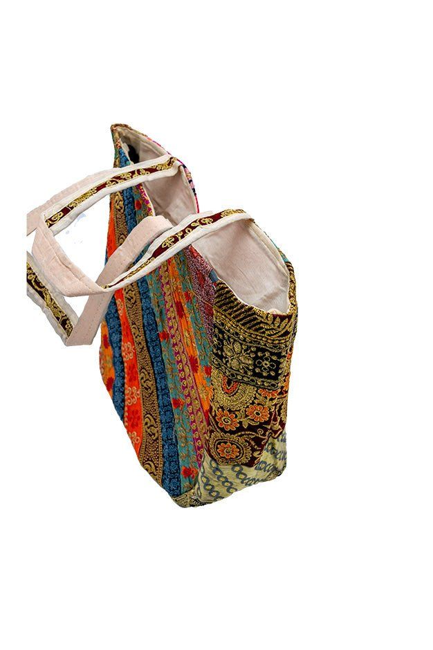 This stunning Artisan tote bag is a true celebration of Indian craftsmanship. The bag features a vibrant and eclectic patchwork design, adorned with intricate Indian gold zari embroidery and shimmering mirrors. Inspired by the nomadic Banjara tribes, this banjara shoulder bag is a perfect blend of tradition and contemporary style. Each piece is meticulously handcrafted, making it a unique and one-of-a-kind accessory. The bag's spacious interior provides ample room for your essentials, while the Artisan Multicolor Rectangular Hobo Bag, Bohemian Rectangular Hobo Bag For Shopping, Multicolor Artisan Hobo Tote Bag, Artisan Multicolor Hobo Tote Bag, Bohemian Style Multicolor Shopping Bag, Bohemian Multicolor Shoulder Bag For Shopping, Bohemian Rectangular Canvas Shopping Bag, Bohemian Style Rectangular Canvas Shopping Bag, Rectangular Patchwork Shoulder Bag For Festivals