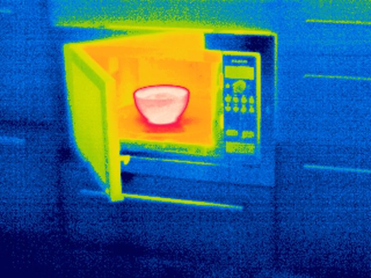 an image of a microwave with the door open and red light coming from inside it